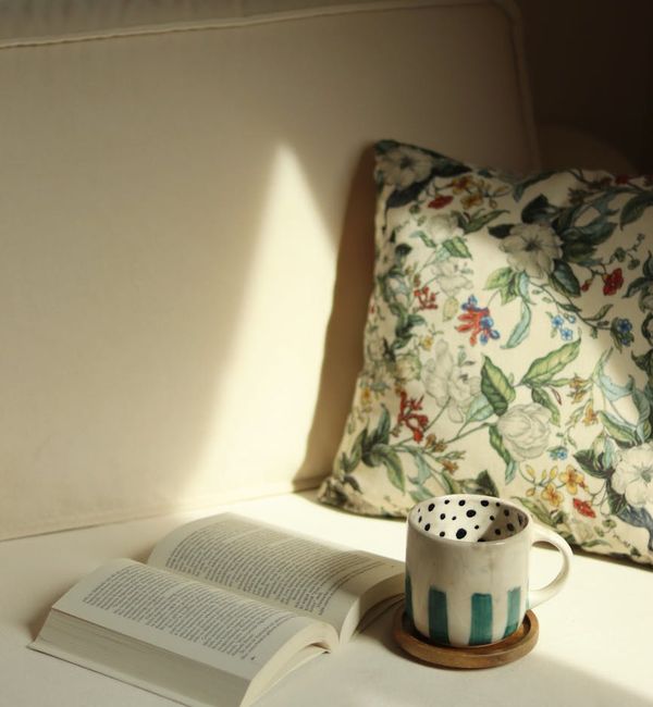 Cozy corner of a room with a yoga mat, plant, and soft morning light.